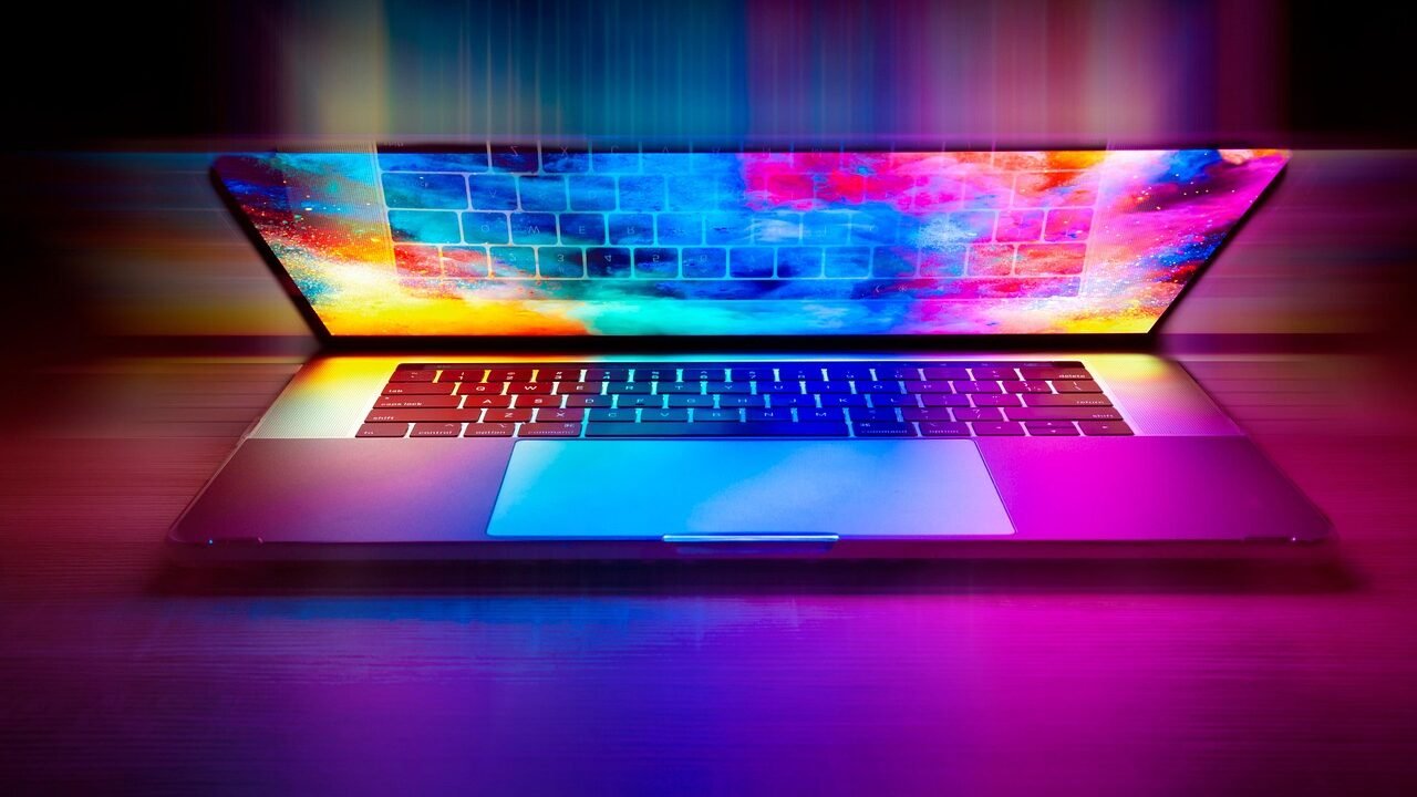 Laptop keyboard lit with vivid rainbow-coloured light, symbolising a late-night online search — used as the header image for 'Is Pornography Illegal in Singapore?