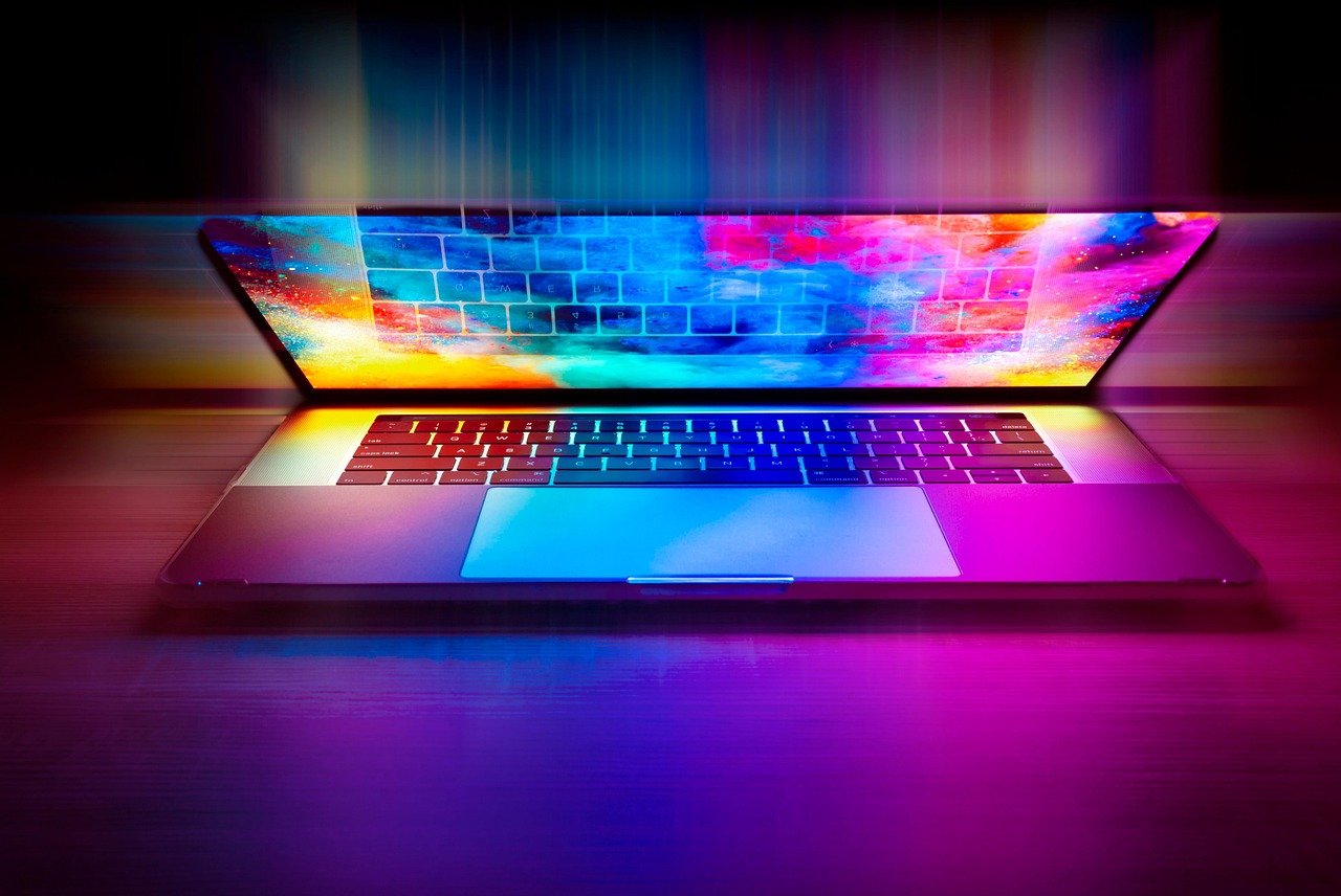 Laptop keyboard lit with vivid rainbow-coloured light, symbolising a late-night online search — used as the header image for 'Is Pornography Illegal in Singapore?
