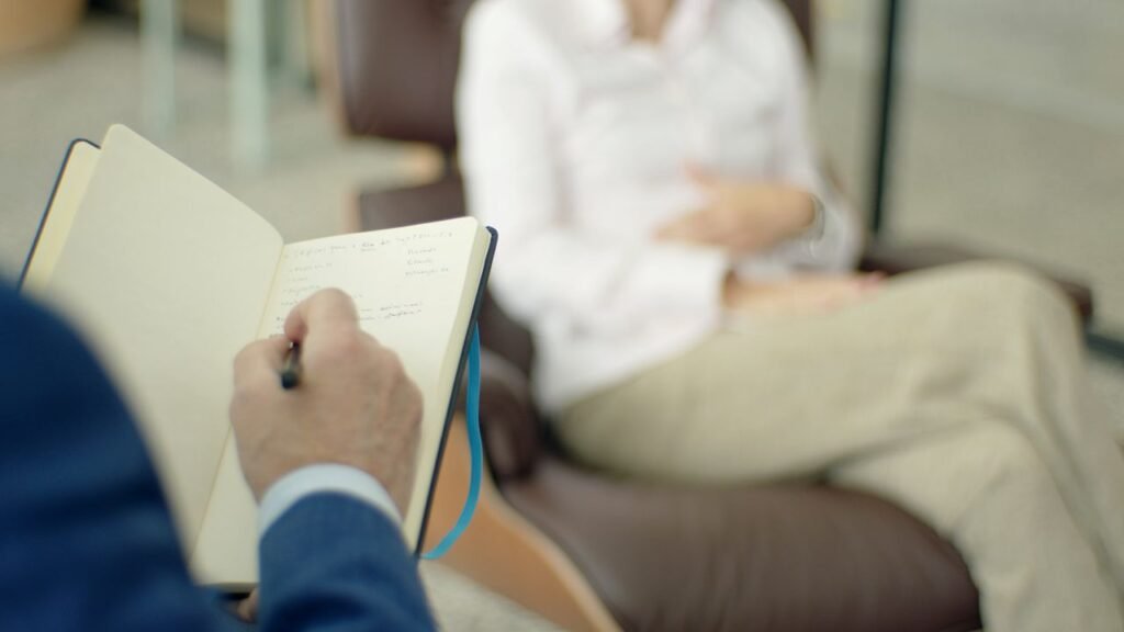 pexels-photo-8430297-8430297 Therapist writing notes during a counseling session with men.