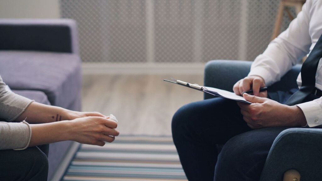 Pricing for therapy session with a registered counsellor and client in Singapore, discussing mental health indoors.